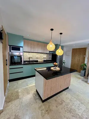 a kitchen with green cabinets and a black counter top at Appartement marrakech in Marrakech