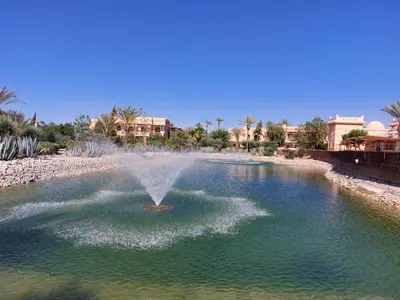 a fountain in the middle of a pool of water at Appartement standing piscine la palmeraie in Marrakech