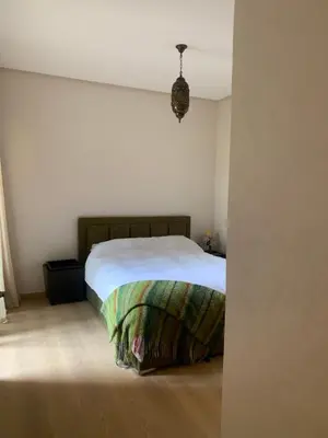 a bedroom with a bed in a white room at Mon paradis Golf & Piscine in Marrakech