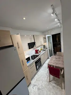 a kitchen with wooden cabinets and a table in it at Résidence Soulaymane اقامة سليمان in Marrakech