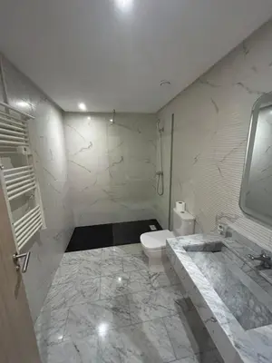 a white bathroom with a toilet and a sink at Appartement spacieux 1 chambre avec piscine Palmeraie Gates in Marrakech