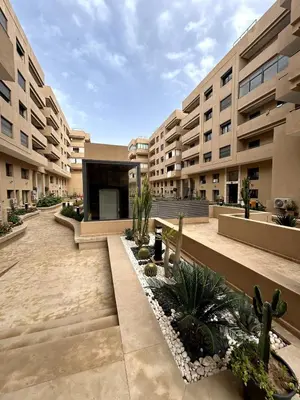 a courtyard of an apartment building with cactus at Appartement spacieux 1 chambre avec piscine Palmeraie Gates in Marrakech