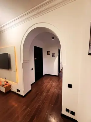an empty room with an archway and wooden floors at Beautiful apartment in a very good location and free parking in Marrakech