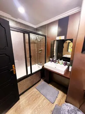 a bathroom with a sink and a large mirror at Beautiful apartment in a very good location and free parking in Marrakech