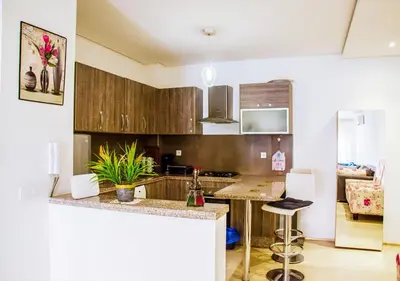 a kitchen with wooden cabinets and a counter top at Appartement Chic et Lumineux, Proche Gare in Marrakech