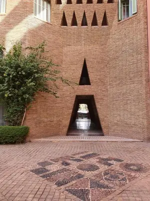 a brick building with a triangle on the side of it at Apartment with pool and garden in Marrakech
