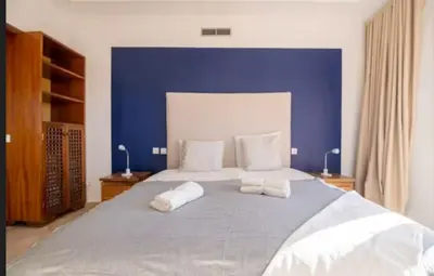 a bedroom with a large bed with a blue wall at Lux apartment With a Sunset View in Marrakech