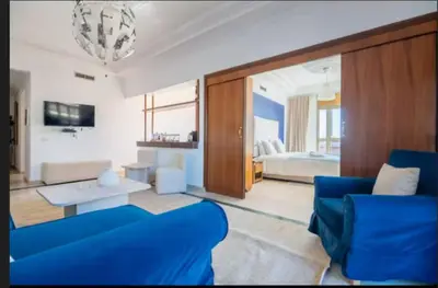 a living room with a blue couch and a bedroom at Lux apartment With a Sunset View in Marrakech