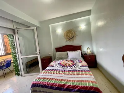 a bedroom with a bed and a large window at Beautiful family apartment with parking in Marrakech