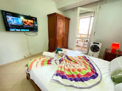 a bedroom with a bed with a colorful blanket on it at Beautiful family apartment with parking in Marrakech