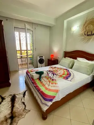 a bedroom with a large bed with a blanket on it at Beautiful family apartment with parking in Marrakech