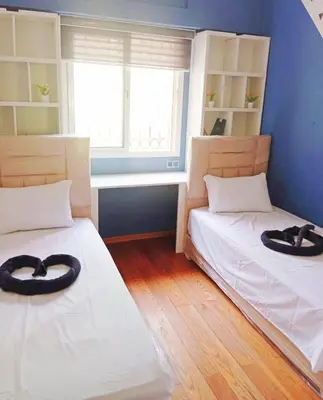 two beds in a room with two hats on them at Cozy Apartment Marrakech Airport in Marrakech