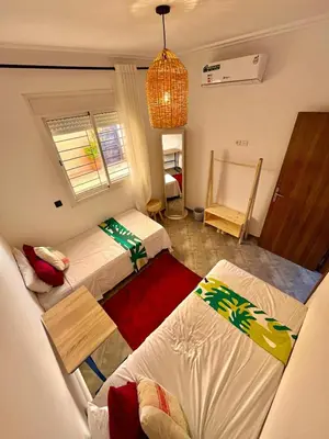 a small room with three beds and a window at Appartement avec piscine privée in Marrakech