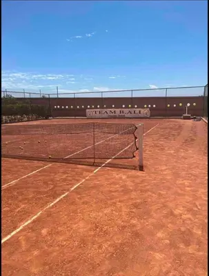 a tennis court with a net on top of it at Superbe appartement Marrakech Piscine Wifi Climatisation in Marrakech