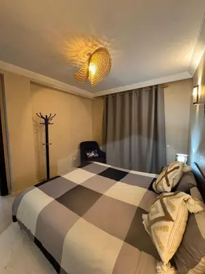 a bedroom with a large bed with a checkerboard pattern at Superbe appartement Marrakech Piscine Wifi Climatisation in Marrakech