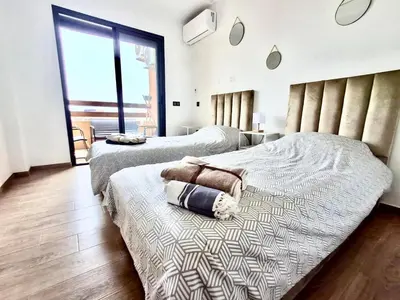 a bedroom with two beds and a large window at Appartement a hivernage in Marrakech