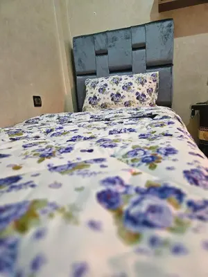 a bed with a blue and white comforter and pillows at Residencia Salma in Marrakech