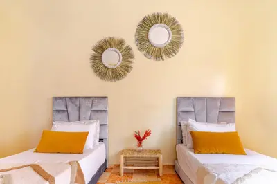 two beds in a room with mirrors on the wall at Jamila home elegance hospitality fiber WiFi in Marrakech
