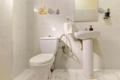 a white bathroom with a toilet and a sink at Jamila home elegance hospitality fiber WiFi in Marrakech