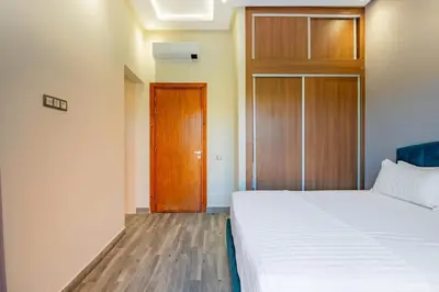 a bedroom with a bed and a wooden door at Villa Izia - Quiet, nature and private pool in Marrakech