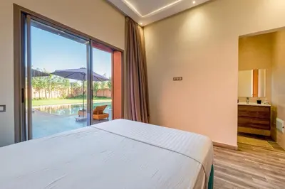 a bedroom with a bed and a large window at Villa Izia - Quiet, nature and private pool in Marrakech