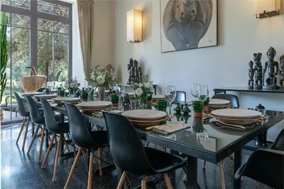 a dining room with a long table and chairs at Dar Toozween in Marrakech