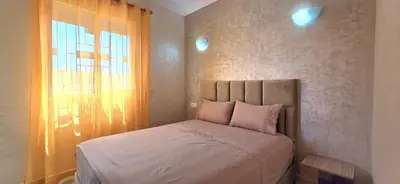 a bedroom with a bed with pink pillows and a window at Nice apart well located 2 Rooms -Only Family in Marrakech