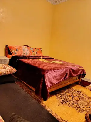 a bedroom with a bed with a red blanket on it at Marrakech mhamid in Marrakech