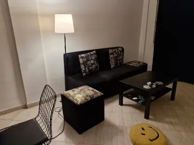 a living room with a black couch and a table at cozy appartement in Marrakech