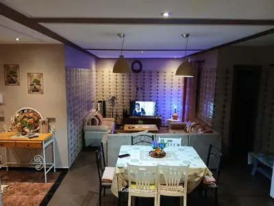 a dining room with a table and a tv at Chambre unique in Marrakech
