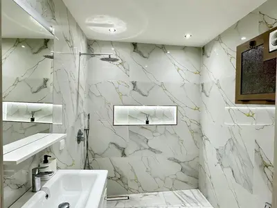 a white bathroom with marble walls and a sink at Elegant Suit in Guéliz in Marrakech