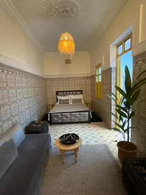 a bedroom with a bed and a couch and a table at Khamsa in Marrakech