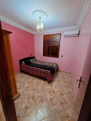 a bedroom with a bed in a pink wall at Nour's PLACE in Marrakech