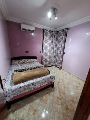 a bedroom with a bed and a purple wall at Nour's PLACE in Marrakech