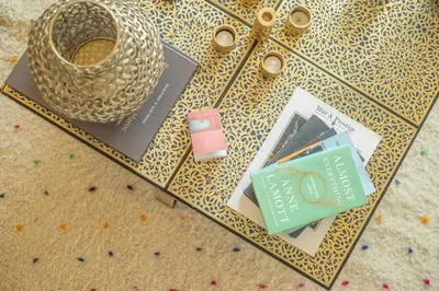 a table with books and a vase on it at Stylish 2BR With Balcony & Designer Touches in Gueliz in Marrakech