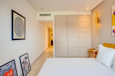 a bedroom with a white bed and a closet at Stylish 2BR With Balcony & Designer Touches in Gueliz in Marrakech