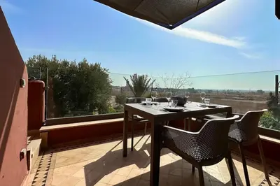 a table and chairs on a balcony with a view at Sunny apartment with rooftop Water Park included in Dar Caïd Layadi