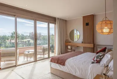 a bedroom with a bed and a view of a balcony at Villa Dar Saliha in Ala el Ma