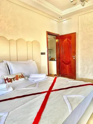 a bedroom with a large bed with a red door at Marrakech in Marrakech