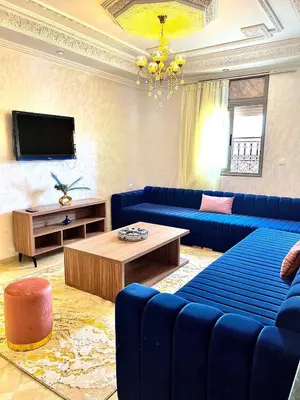 a living room with blue couches and a tv at Marrakech in Marrakech