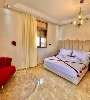 a bedroom with a large bed and a red chair at Marrakech in Marrakech
