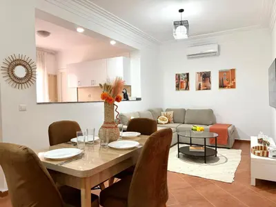 a dining room and living room with a table and chairs at Le Cosy Nejmaa - Piscine - 4 Prs - Marrakech in Marrakech