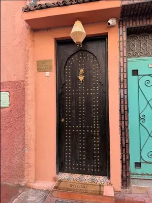 a black door with a cross on it on a building at Riad L'EncensOriental & Spa in Marrakech