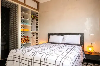 a bedroom with a bed and a book shelf at Marjane Allal Fassi 2 chambres Bedrooms 2 Bathrooms Wi-Fi fibre climatisation in Marrakech