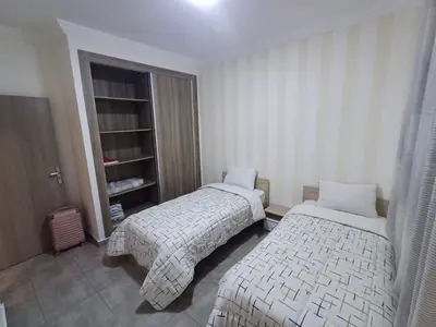 a bedroom with two beds and a book shelf at Cosy 2-bedroom apt in Ourika Route in Marrakech