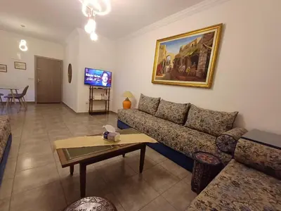 a living room with a couch and a table at Cosy 2-bedroom apt in Ourika Route in Marrakech