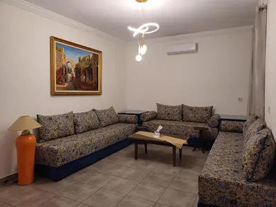 a living room with a couch and a table at Cosy 2-bedroom apt in Ourika Route in Marrakech