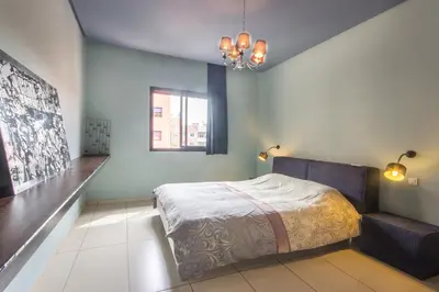 a bedroom with a bed and a window and a couch at Apartment with Private Rooftop & Jaccuzzi in Marrakech