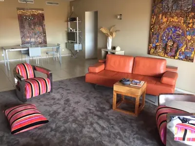 a living room with an orange couch and a table at Apartment with Private Rooftop & Jaccuzzi in Marrakech