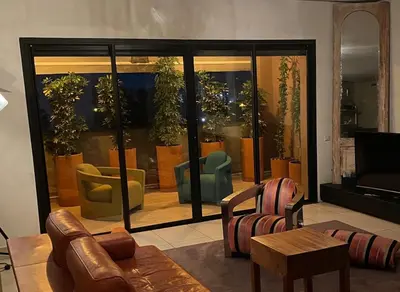 a living room with furniture and a large glass window at Apartment with Private Rooftop & Jaccuzzi in Marrakech